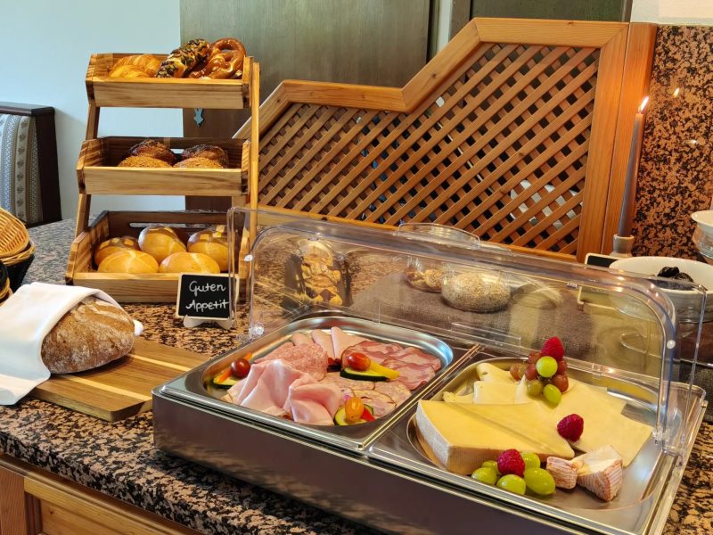 Reich gedeckter Frühstückstisch mit frischen Erdbeeren, Eiern und Kaffee