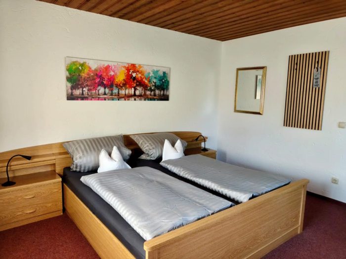 Frisch renoviertes Doppelzimmer mit breitem Doppelbett und viel Tageslicht